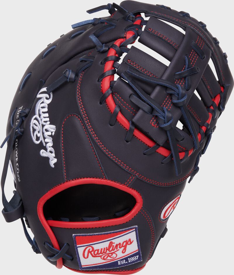 Navy back of a NXT Series 12.25" 1st base mitt with a red, white, & blue Rawlings patch loading=