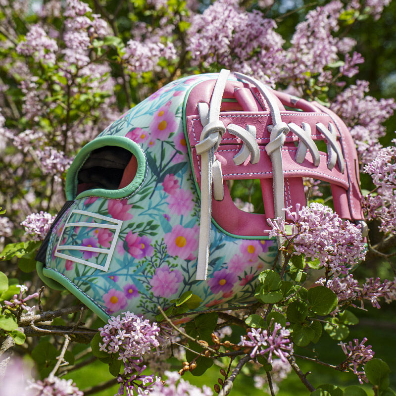 Picture of a Rawlings Mother's Day REV1X infield glove in a flower bush loading=