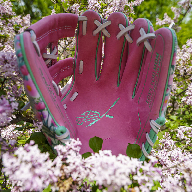 Picture of the pink leather palm of a Rawlings Race Day REV1X infield glove in a flower bush loading=