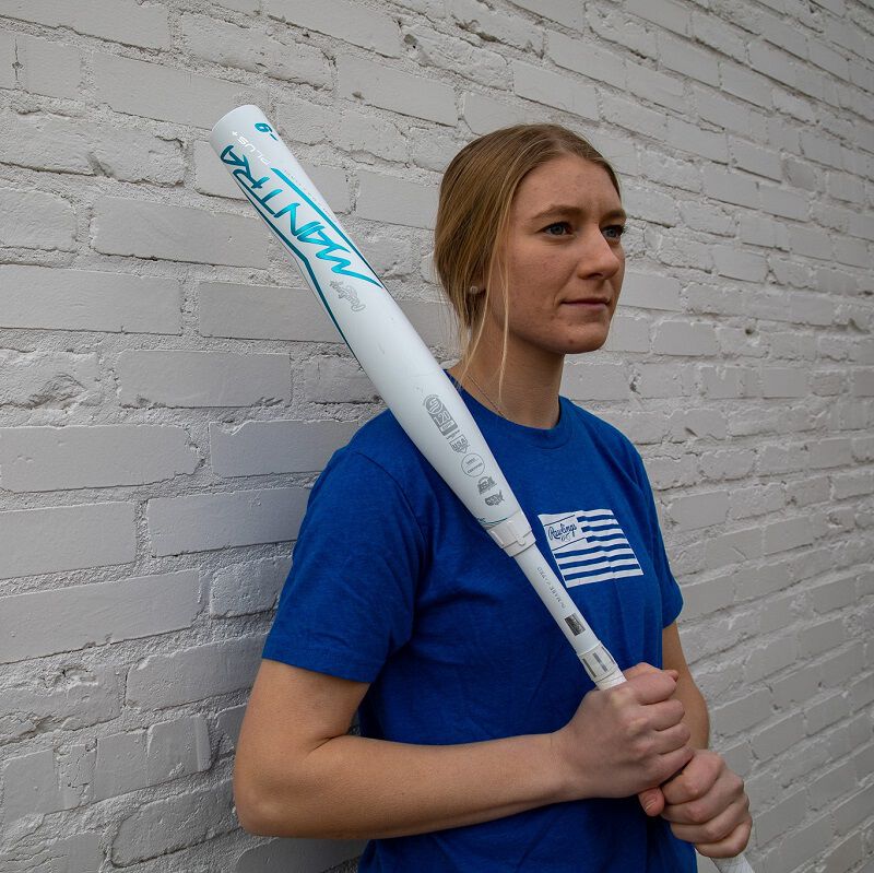 A player standing in front of a white wall holding a Rawlings Mantra+ softball bat - SKU: RFP3MP loading=