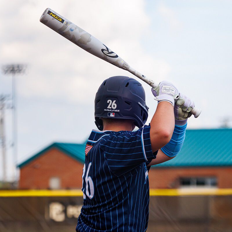 Picture from behind of a player standing with a 2025 Icon USSSA bat loading=