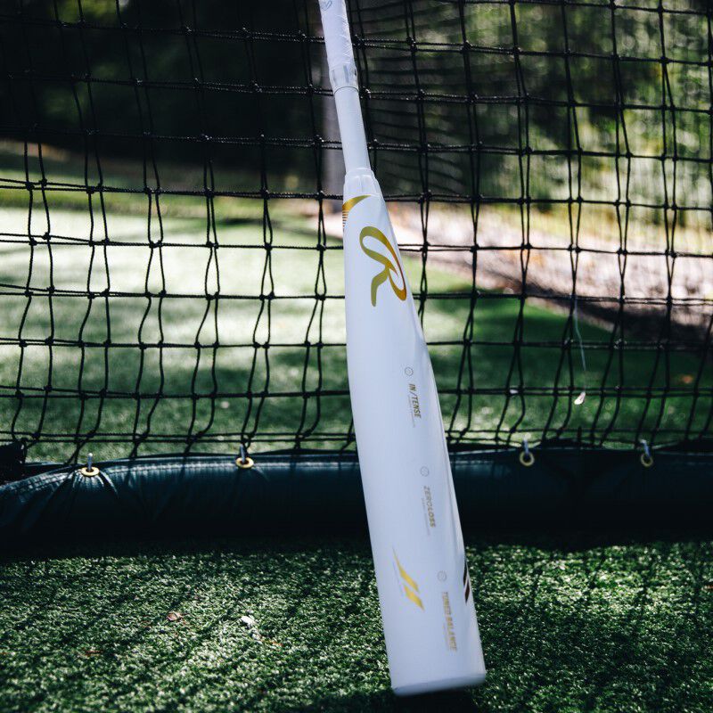 A white Rawlings Icon USSSA bat leaning against a batting cage - SKU: RUT4I loading=